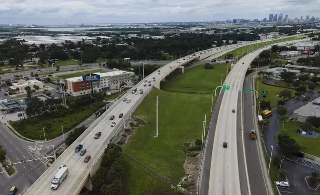 In this image taken with a drone, the Tampa, Fla., skyline, top right, is seen at a distance as traffic flows eastbound, left lanes, along Interstate 4 as residents continue to follow evacuation orders ahead of Hurricane Milton, Tuesday, Oct. 8, 2024. (AP Photo/Julio Cortez)