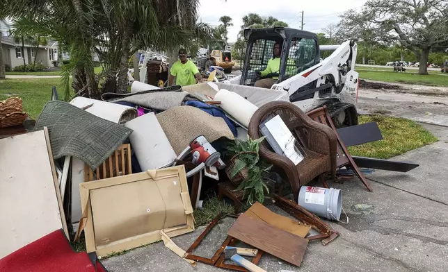 Contractors with the City of New Port Richey help clean debris left by Hurricane Helene in preparation for Hurricane Milton on Monday, Oct. 7, 2024, in New Port Richey, Fla. (AP Photo/Mike Carlson)