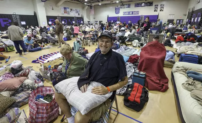 Stephen Gandy, one of 700 evacuees sheltering in the gymnasium at River Ridge Middle/High School in preparation for Hurricane Milton, smiles on Wednesday, Oct. 9, 2024, in New Port Richey, Fla. (AP Photo/Mike Carlson)