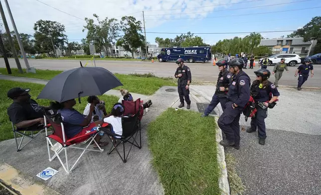 FEMA officials talk to residents displaced out of their apartment complex during Hurricane Milton, Friday, Oct. 11, 2024, in Clearwater, Fla. (AP Photo/Julio Cortez)