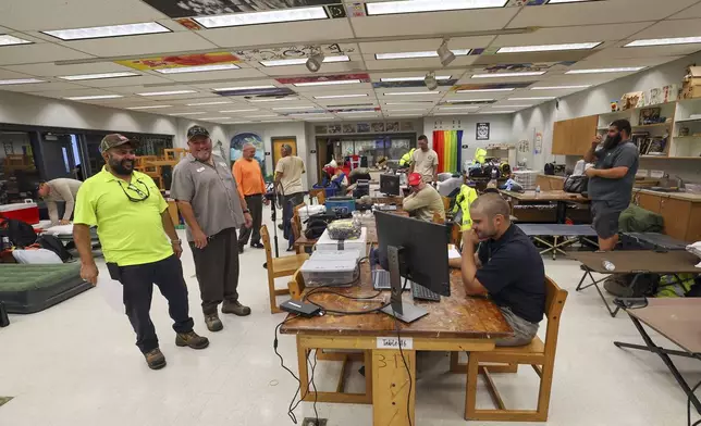 Members of Pasco County utilities set up in classrooms of a hurricane shelter at River Ridge Middle/High School in preparation for Hurricane Milton, Wednesday, Oct. 9, 2024, in New Port Richey, Fla. (AP Photo/Mike Carlson)