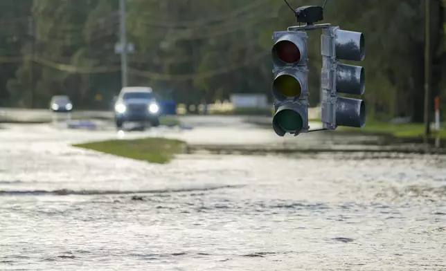 A traffic light hangs low as flood waters cover a road the morning after Hurricane Milton hit the region, Thursday, Oct. 10, 2024, in Tampa, Fla. (AP Photo/Julio Cortez)