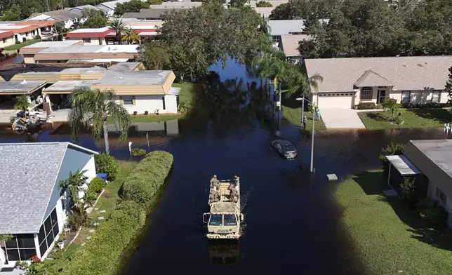 A truck from the Florida National Guard goes out to help residents trapped in their homes as waters rise after Hurricane Milton caused the Anclote River to flood, Friday, Oct. 12, 2024, in New Port Richey, Fla. (AP Photo/Mike Carlson)