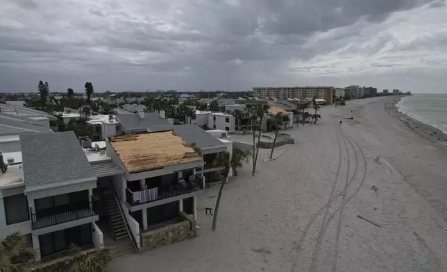 Ron Dyer, who has lived full-time at Bahia Vista Gulf with his wife Jean since 2019, sits on the balcony of their beachfront condo, which lost part of its roof in the passage of Hurricane Milton, on the island of Venice, Fla., Friday, Oct. 11, 2024. (AP Photo/Rebecca Blackwell)