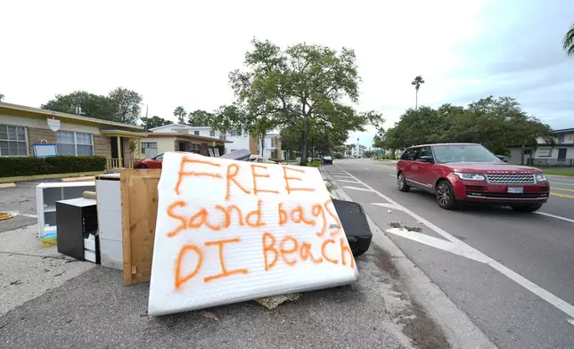 A message is seen on a mattress on a pile of furniture destroyed during Hurricane Helene as residents in the Davis Islands community of Tampa, Fla., prepare for the arrival of Hurricane Milton, Tuesday, Oct. 8, 2024. (AP Photo/Julio Cortez)