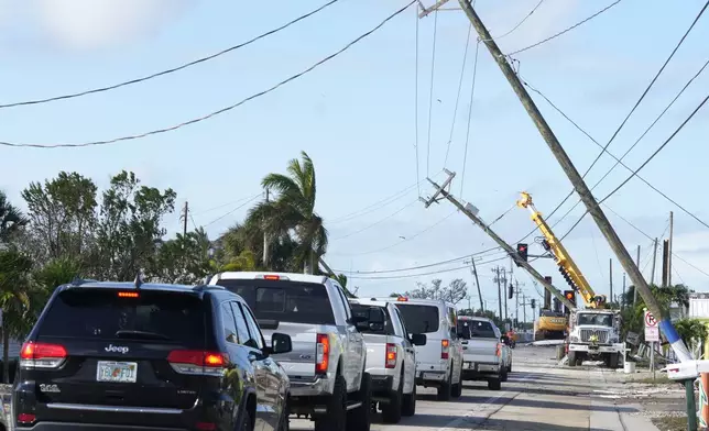 Cars move slowly after Hurricane Milton damaged power lines, Thursday, Oct. 10, 2024, in Matlacha, Fla. (AP Photo/Marta Lavandier)