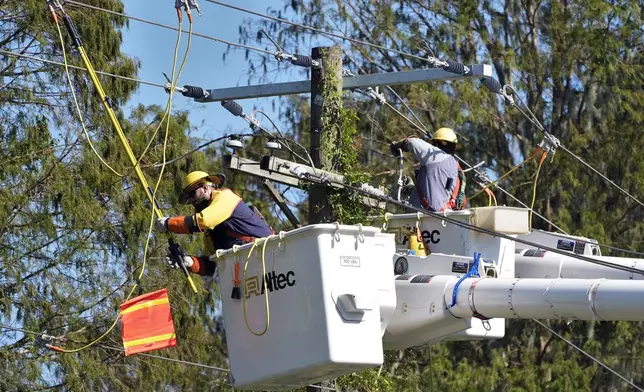 Pike Corporation linemen, from North Carolina, work on power lines damaged by Hurricane Milton Monday, Oct. 14, 2024, in Lithia, Fla. (AP Photo/Chris O'Meara)