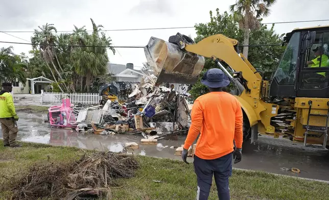 Salvage works remove debris from Hurricane Helene flooding along the Gulf of Mexico Monday, Oct. 7, 2024, in Clearwater Beach, Fla. Crews are working to remove the debris before Hurricane Milton approaches Florida's west coast. (AP Photo/Chris O'Meara)