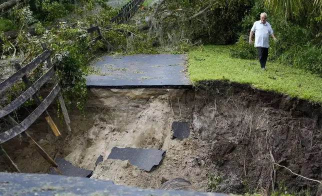 Del Ockey, a seasonal Florida resident from Canada, walks near the damaged bridge from Hurricane Milton, that leads onto his property, Friday, Oct. 11, 2024, in Riverview, Fla. (AP Photo/Julio Cortez)