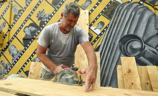 Jay McCoy puts up plywood in preparation for Hurricane Milton on Monday, Oct. 7, 2024, in New Port Richey, Fla. (AP Photo/Mike Carlson)