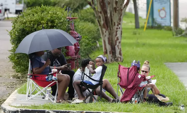 Residents wait to get access back into the apartment complex which was flooded by Hurricane Milton, Friday, Oct. 11, 2024, in Clearwater, Fla. (AP Photo/Julio Cortez)