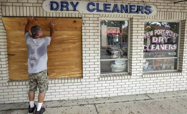 Jay McCoy puts up plywood in preparation for Hurricane Milton on Monday, Oct. 7, 2024, in New Port Richey, Fla. (AP Photo/Mike Carlson)