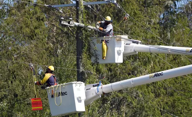 Pike Corporation linemen from North Caolina, repair power pole damaged by Hurricane Milton Monday, Oct. 14, 2024, in Lithia, Fla. (AP Photo/Chris O'Meara)