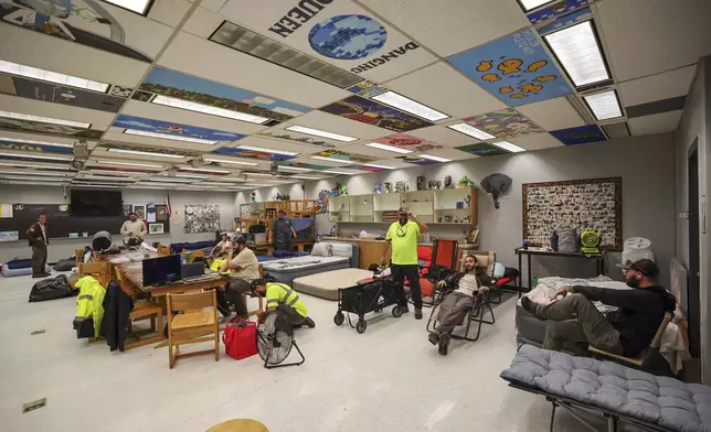 Members of Pasco County utilities set up in classrooms in a hurricane shelter at River Ridge Middle/High School in preparation for Hurricane Milton, Wednesday, Oct. 9, 2024, in New Port Richey, Fla. (AP Photo/Mike Carlson)