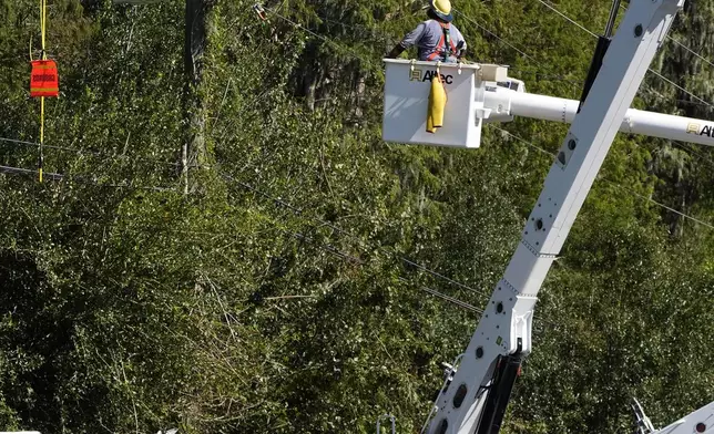 Pike Corporation linemen, of North Carolina, repair power lines damaged by Hurricane Milton Monday, Oct. 14, 2024, in Lithia, Fla. (AP Photo/Chris O'Meara)