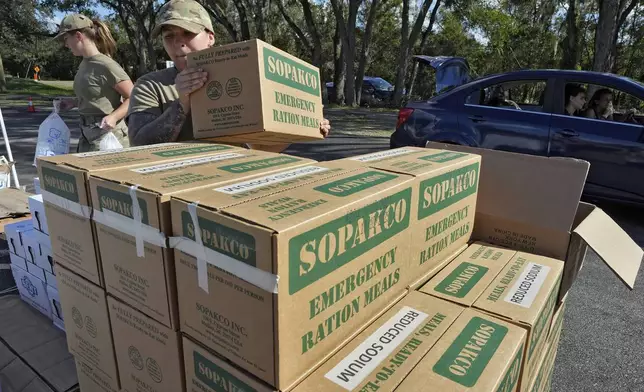 Members of the Florida Air National Guard load supplies into the cars of residents displaced by Hurricane Milton, Sunday, Oct. 13, 2024, at the Hillsborough Community College campus in Brandon, Fla. (AP Photo/Chris O'Meara)