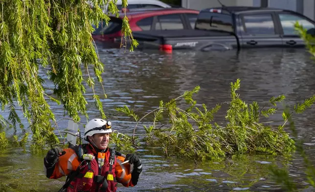 A water rescue team member walks through flood waters at an apartment complex in the aftermath of Hurricane Milton, Thursday, Oct. 10, 2024, in Clearwater, Fla. (AP Photo/Mike Stewart)