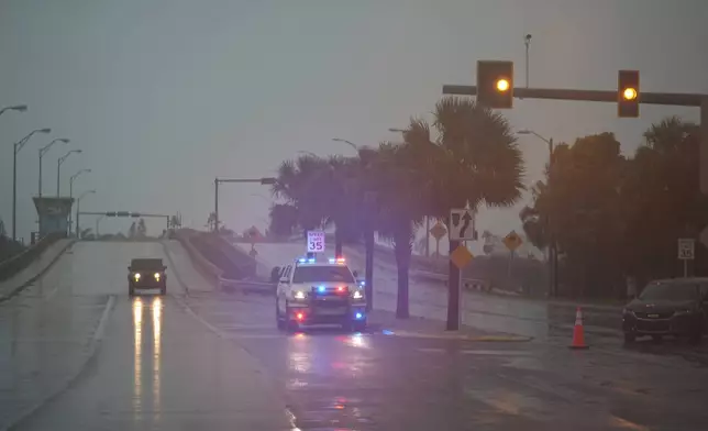 Police block off a bridge leading to the barrier island of St. Pete Beach, Fla., ahead of the arrival of Hurricane Milton, in South Pasadena, Fla., Wednesday, Oct. 9, 2024. (AP Photo/Rebecca Blackwell)