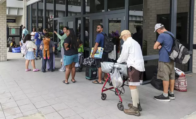 Pasco County evacuees await the opening of the shelter at River Ridge High School in preparation for Hurricane Milton on Monday, Oct. 7, 2024, in New Port Richey, Fla. (AP Photo/Mike Carlson)