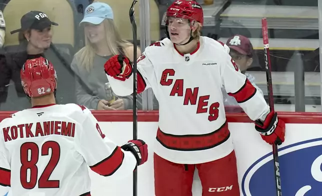 Carolina Hurricanes' Jackson Blake, right, celebrates with Jesperi Kotkaniemi (82) after scoring during the first period of an NHL hockey game against the Pittsburgh Penguins, Friday, Oct. 18, 2024, in Pittsburgh. (AP Photo/Matt Freed)