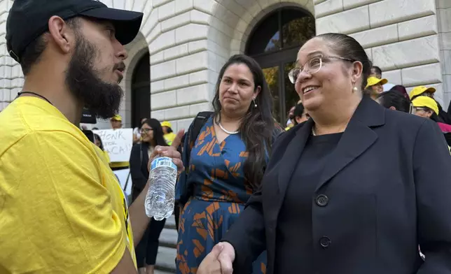 Attorney Nina Perales, vice president of litigation for the Mexican American Legal Defense and Educational Fund, shakes hands with a DACA supporter outside federal appellate court in New Orleans following a hearing to decide the policy's future on Thursday, Oct. 10, 2024. (AP Photo/Jack Brook)