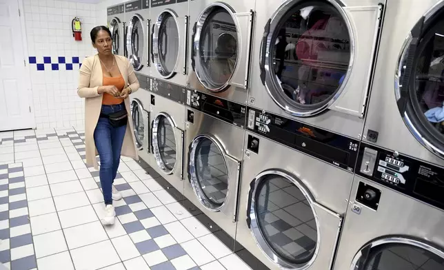 Sofia Roca, an immigrant from Colombia, washes clothes at a laundromat in Aurora, Colorado, on March 29, 2024. (AP Photo/Thomas Peipert)