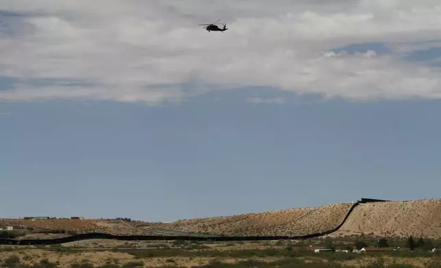 A surveillance helicopter traces a line in the sky above the Southwest border with Mexico at Sunland Park, N.M., Thursday, Aug. 22, 2024. (AP Photo/Morgan Lee, File)