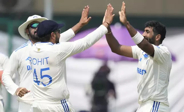 India's Jasprit Bumrah, right and India's captain Rohit Sharma celebrates the wicket of Bangladesh's Mehidy Hasan Miraz on the fifth and final day of the second cricket test match between Bangladesh and India in Kanpur, India, Tuesday, October 1, 2024. (AP Photo/Ajit Solanki)