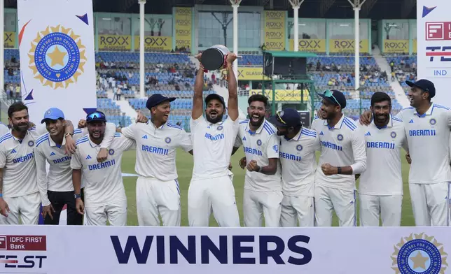 Indian players celebrate with the trophy after winning the two test match series against Bangladesh in Kanpur, India, Tuesday, October. 1, 2024. (AP Photo/Ajit Solanki)