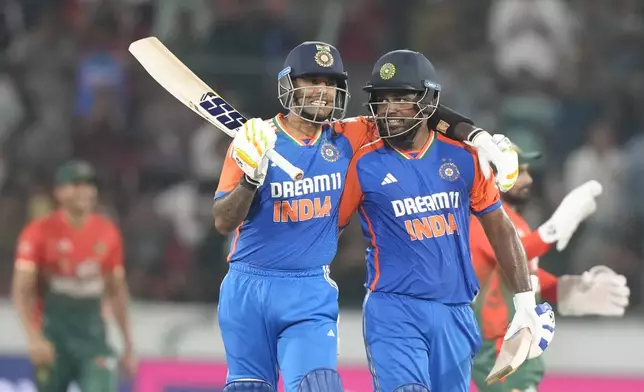 India's Sanju Samson, right, gesture with captain Suryakumar Yadav while walks back to the pavilion after losing his wicket to Bangladesh's Mustafizur Rahman during the third and final T20 cricket match between Bangladesh and India in Hyderabad, India, Saturday, Oct. 12, 2024. (AP Photo/Mahesh Kumar A.)