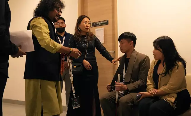 Takosangba Jamir, 27, a blind pianist, second right, is introduced to other artists by festival director Khyochano TCK, center, as he waits backstage for his performance at the two-day Brillante Piano Festival in Bengaluru, India, Sunday, Sept. 29, 2024. (AP Photo/Aijaz Rahi)