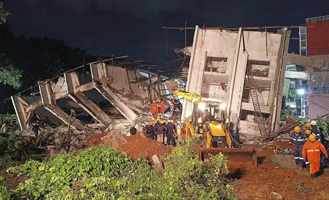 Rescue workers look for the trapped survivors under the debris of an under construction building that collapsed following heavy rains in Bengaluru, India, Tuesday, Oct. 22, 2024. (AP Photo)