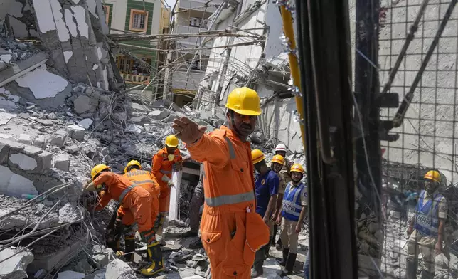 Rescue workers look for the trapped survivors under the debris of an under-construction building that collapsed on Tuesday, following heavy rains in Bengaluru, India, Wednesday, Oct. 23, 2024. (AP Photo/Aijaz Rahi)