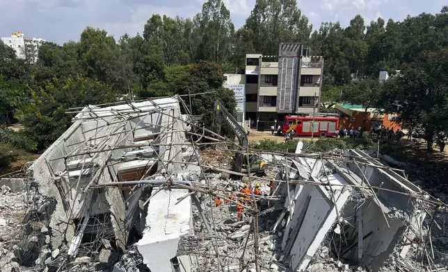 Rescue workers look for the trapped survivors under the debris of an under-construction building that collapsed on Tuesday, following heavy rains in Bengaluru, India, Wednesday, Oct. 23, 2024. (AP Photo/Aijaz Rahi)