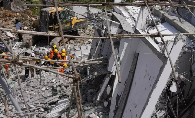 Rescue workers look for the trapped survivors under the debris of an under-construction building that collapsed on Tuesday, following heavy rains in Bengaluru, India, Wednesday, Oct. 23, 2024. (AP Photo/Aijaz Rahi)