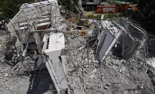 Rescue workers look for the trapped survivors under the debris of an under-construction building that collapsed on Tuesday, following heavy rains in Bengaluru, India, Wednesday, Oct. 23, 2024. (AP Photo/Aijaz Rahi)