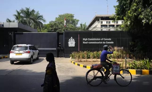 A cyclist pedals past the Canadian high commission in New Delhi, India, Tuesday, Oct. 15, 2024 after India and Canada expelled each other’s top diplomats over an ongoing dispute about the killing of a Sikh activist in Canada. (AP Photo/Manish Swarup)