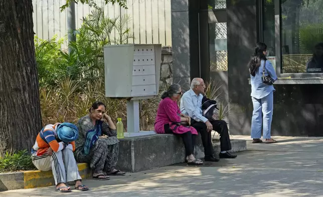 People wait outside the Canadian high commission in New Delhi, India, Tuesday, Oct. 15, 2024 after India and Canada expelled each other’s top diplomats over an ongoing dispute about the killing of a Sikh activist in Canada. (AP Photo/Manish Swarup)