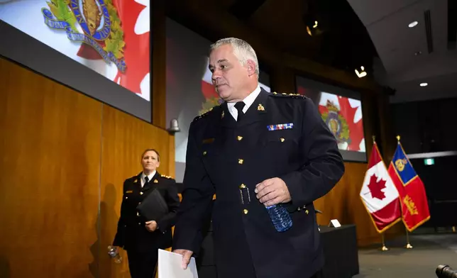 RCMP Commissioner Mike Duheme, centre, and Assistant Commissioner Brigitte Gauvin leave after speaking at a news conference at RCMP National Headquarters in Ottawa, Ontaio, Monday, Oct. 14, 2024. (Justin Tang/The Canadian Press via AP)