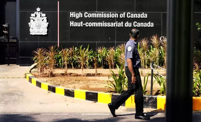 A private security man walks outside the Canadian high commission in New Delhi, India, Tuesday, Oct. 15, 2024 after India and Canada expelled each other’s top diplomats over an ongoing dispute about the killing of a Sikh activist in Canada. (AP Photo/Manish Swarup)