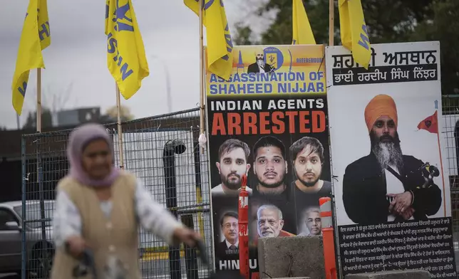 A photograph of late temple president Hardeep Singh Nijjar, back right, is displayed outside the Guru Nanak Sikh Gurdwara Sahib, in Surrey, British Columbia, Tuesday, Oct. 15, 2024. (Darryl Dyck/The Canadian Press via AP)