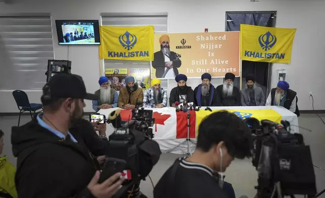 Guru Nanak Sikh Gurdwara Sahib spokesperson and youth leader, Gurkeerat Singh, back forth from left, speaks during a news conference, in Surrey, British Columbia, Tuesday, Oct. 15, 2024. (Darryl Dyck/The Canadian Press via AP)