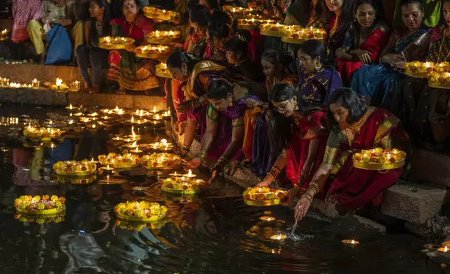 FILE- Hindu women light oil lamps at the Banganga pond as they celebrate Dev Diwali festival in Mumbai, India, Nov. 7, 2022. (AP Photo/Rafiq Maqbool, File)