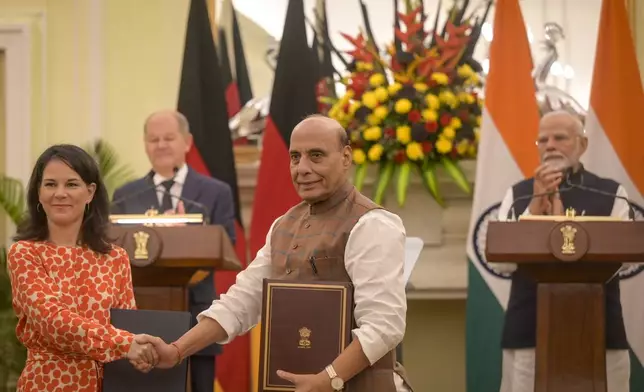 India's Defense Minister, Rajnath Singh, second right, shakes hands with Germany's Minister for Foreign Affairs Annalena Baerbock, as Indian Prime Minister Narendra Modi, right, and German Chancellor Olaf Scholz, applaud after bilateral talks in New Delhi, India, Friday, Oct. 25, 2024. (AP Photo)