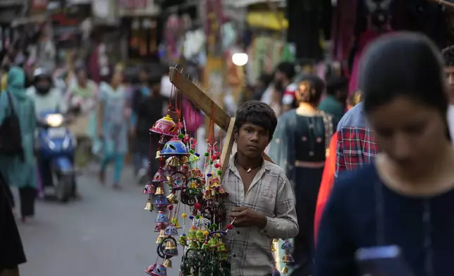 A boy sells artificial decorative flowers of a crowded market on the eve of Diwali, the Hindu festival of lights, in Jammu, India, Wednesday, Oct. 30, 2024.Diwali is one of Hinduism's most important festivals, dedicated to the worship of the goddess of wealth Lakshmi. (AP Photo/Channi Anand)