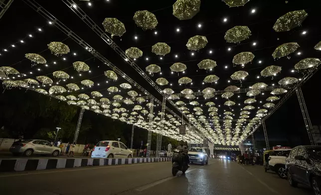 Commuters move on an illuminated road at the Hindu festival of lights Diwali in Ahmedabad, India, Thursday, Oct. 31, 2024. (AP Photo/Ajit Solanki)