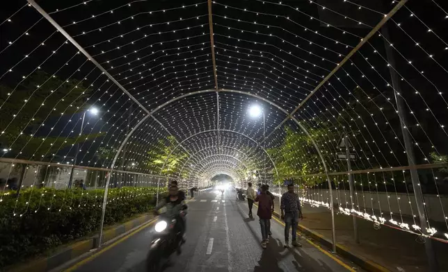 Commuters move on an illuminated road ahead of the Hindu festival of lights Diwali in Ahmedabad, India, Thursday, Oct. 31, 2024. (AP Photo/Ajit Solanki)