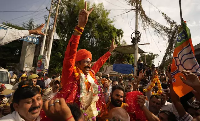 Bharatiya Janata Party (BJP) candidate Mohan lal bhagat greets supporters after victory in Jammu, India, Tuesday, Oct. 8, 2024. (AP Photo/Channi Anand)