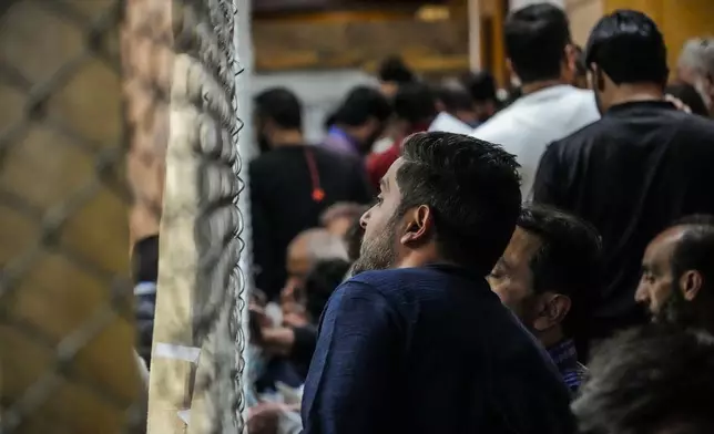 A political party representative watches as polling officials count the votes in the recent election for a local government in Indian-controlled Kashmir on the outskirts of Srinagar, Tuesday, Oct. 8, 2024. (AP Photo/Mukhtar Khan)