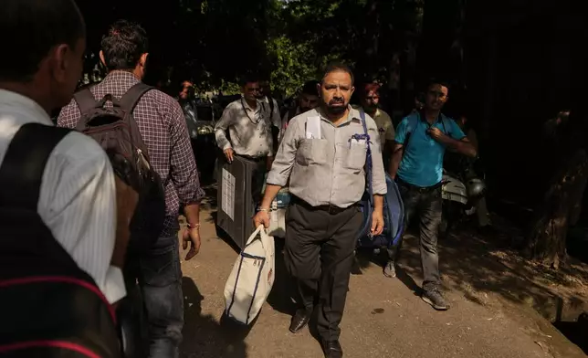 Polling officials leave with electronic voting machines and other election material on the eve of the third phase of the Jammu and Kashmir Assembly election, in Jammu, India, Monday, Sept.30, 2024. (AP Photo/Channi Anand)